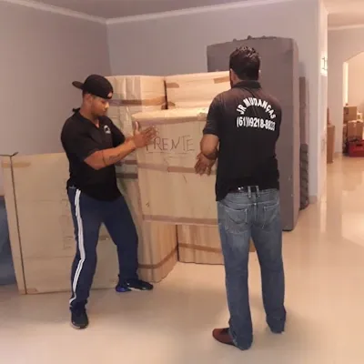 Equipe transportando um móvel embalado